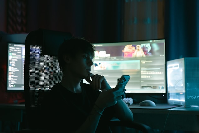 A builder working late at a computer, lit by the screen